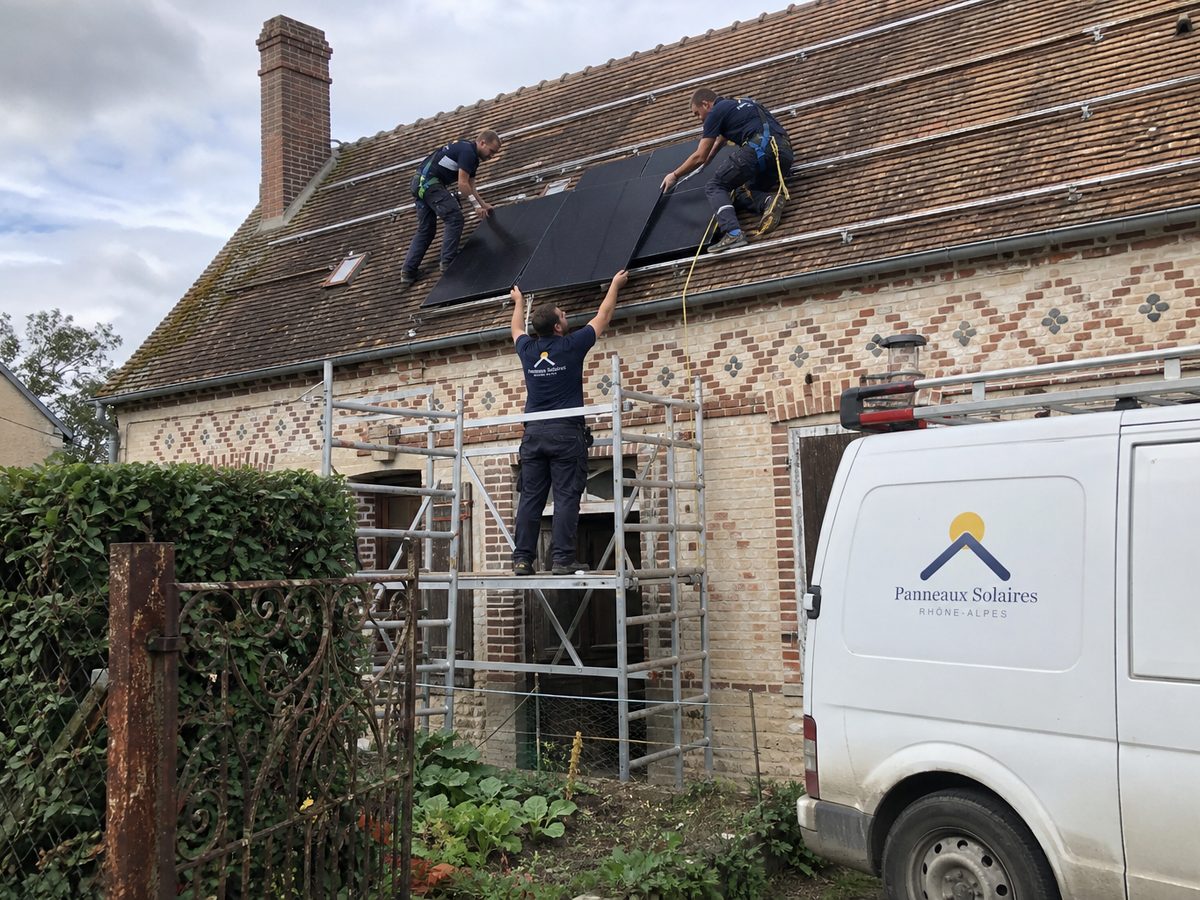 Pose de panneaux sur une maison en brique vernissée, le camion dans le chemin