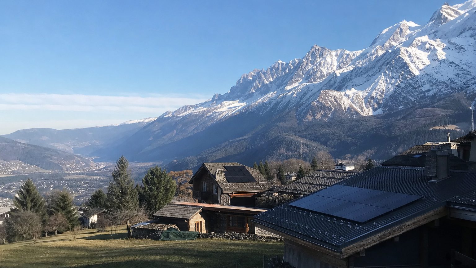 Chalets dans une vallée face à un massif enneigé