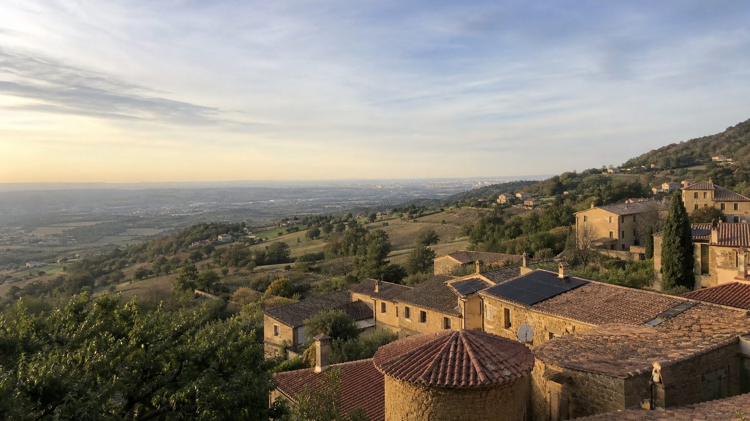 Villages de pierres dorées sur les collines, la ville au loin, quelques toits équipés de panneaux