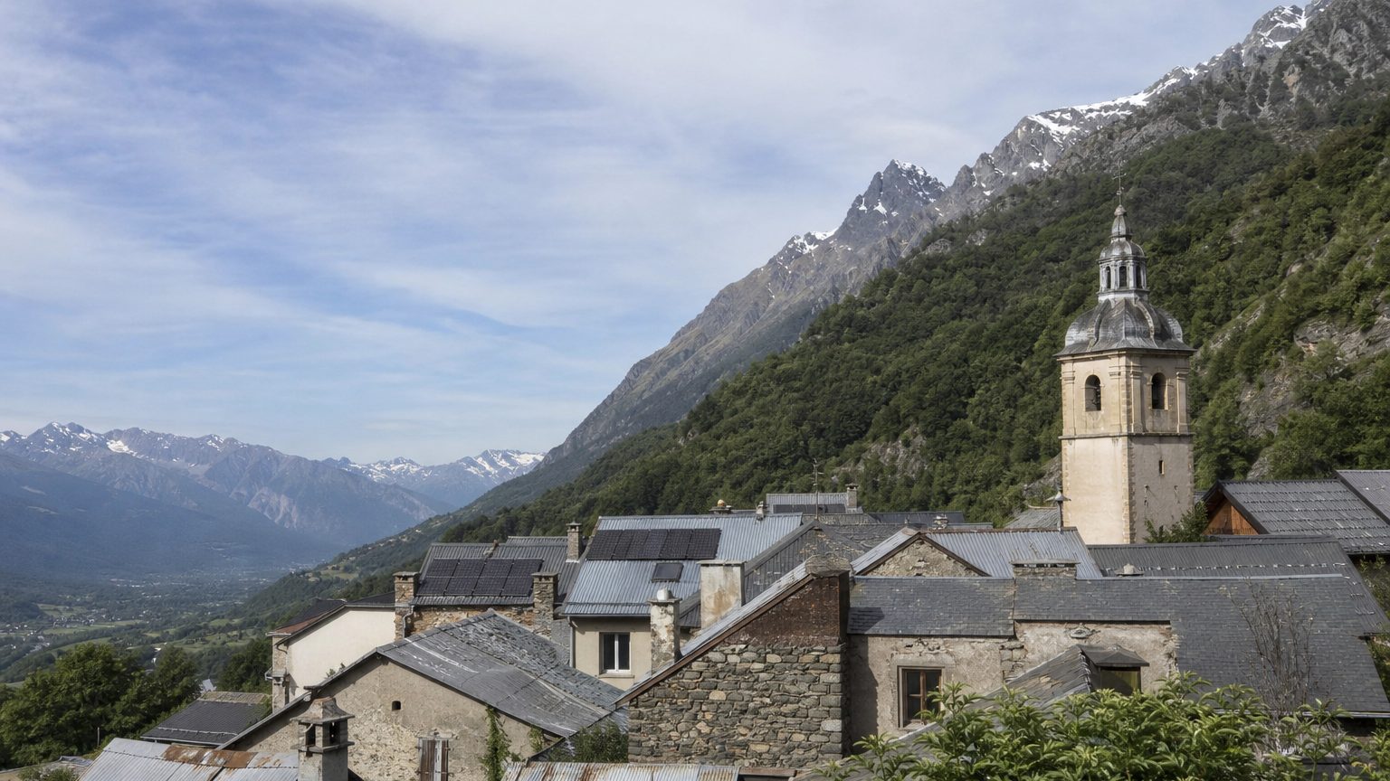 Village de montagne, toits d'ardoise et de tôle, clocher et sommets enneigés