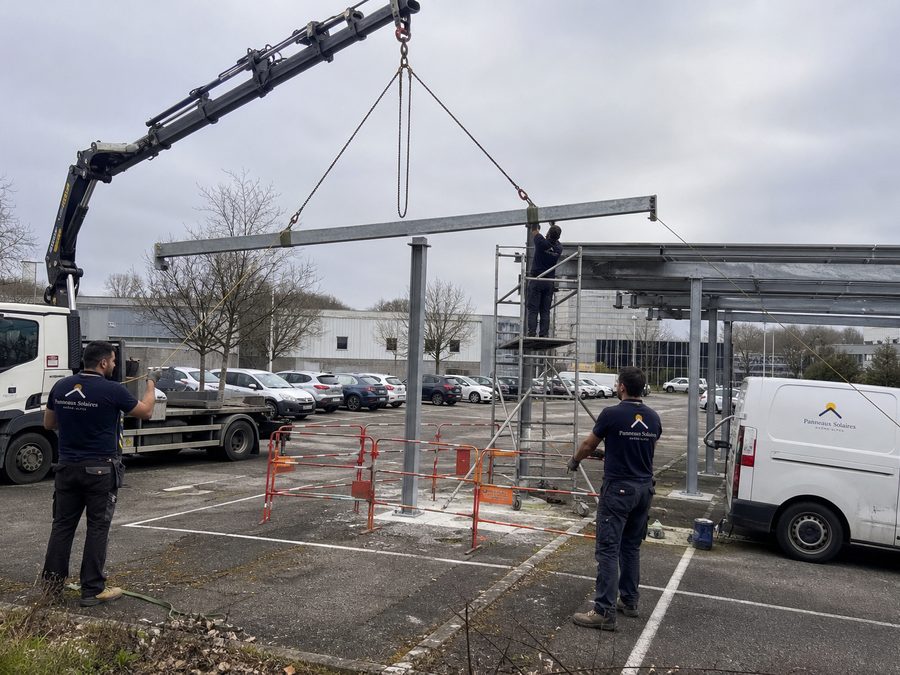 Pose de la charpente de l'ombrière au camion-grue, le reste du parking reste ouvert