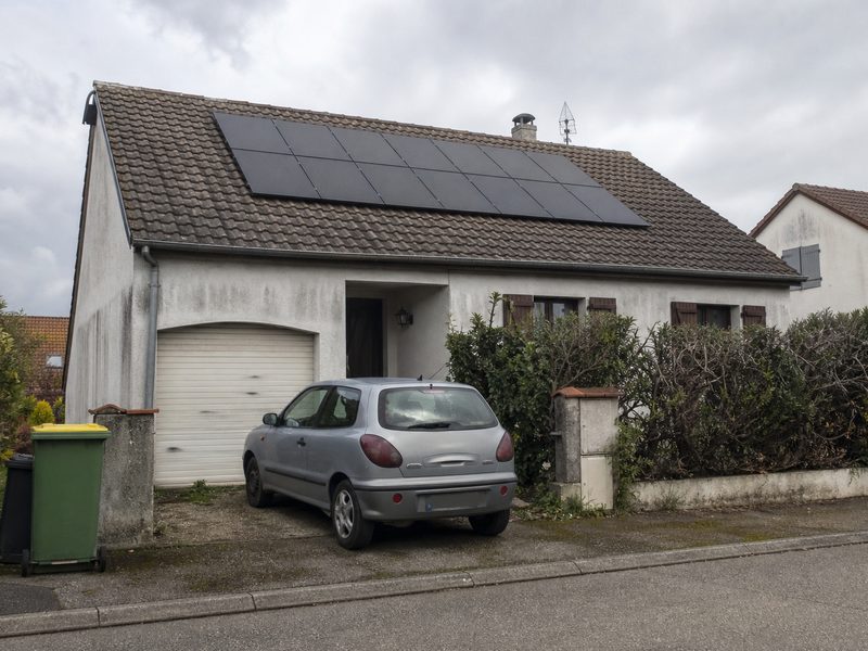Maison des années 1980 du Nord-Isère, quinze panneaux noirs posés sur les tuiles mécaniques